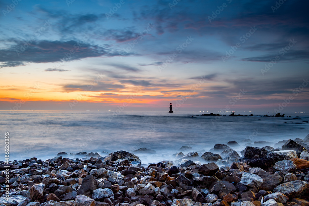 Fototapeta premium Sunrise on the beach with a view of the lighthouse 