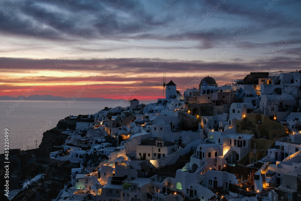Amazing sunset at the picturesque and illuminated  village of Oia  in Santorini Greece