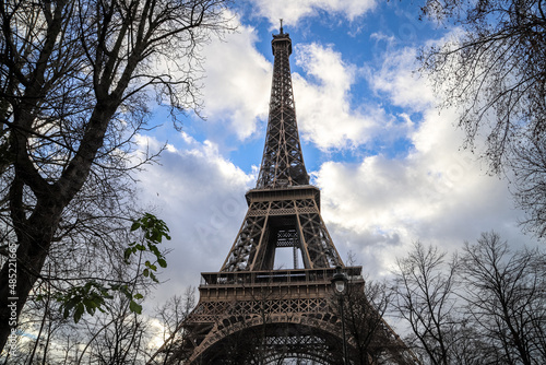 eiffel tower in paris through trees of champ du mars and close up © David Delgado
