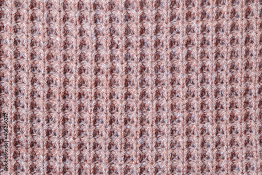 Texture of knitted woolen fabric of light red color.