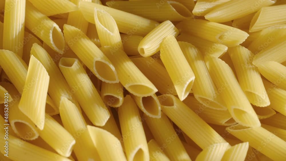 Top view of raw fresh pasta penne rigate rotate on tray. Penne Rigate macaroni. Traditional Italian Cuisine. Durum wheat pasta. Food background. Top view of raw fresh pasta penne rigate rotate on tray. Penne Rigate macaroni. Traditional Italian Cuisine. Durum wheat pasta. Food background.