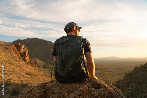 Male hiker enjoying a golden sunrise and sunset with the cactuses in Tucson Arizona in Saguaro National Park