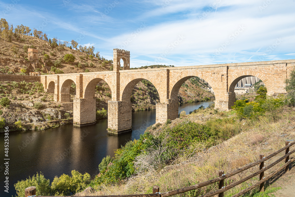 Stone old bridge over river in summertime - obrazy, fototapety, plakaty 
