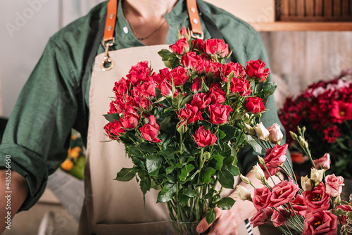Florist make gift bouquets. Graceful female hands make a beautiful bouquet. Florist workplace. Small business concept. Flowers and accessories. Hands stock photo