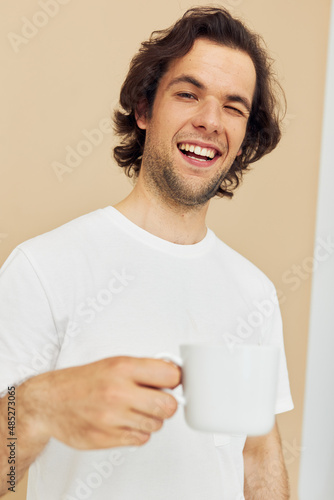 handsome man with a white mug in his hands emotions posing isolated background