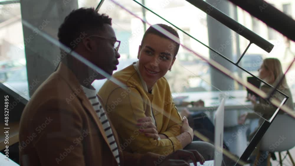 Handsome young African American business man and short hair woman working on laptop while sitting at office
Handsome young African American business man and short hair woman working on laptop while sitting at office