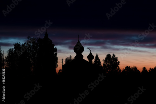 colorful sunset over church with rickety cross © Алексей Ромадов