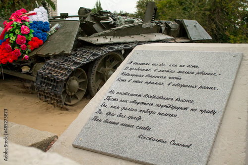 Carved poems about war against background of destroyed tank photo