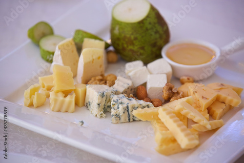 Fototapeta Naklejka Na Ścianę i Meble -  Different assortment of cheese on a plate. Menus for restaurants and cafes. Decoration with various ingredients.