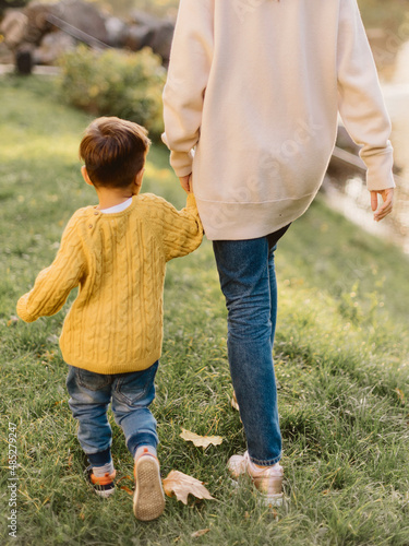 parent and child walking in a park on green grass