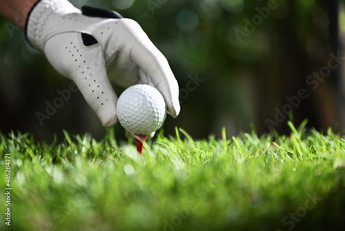 golfer putting golf ball on tee