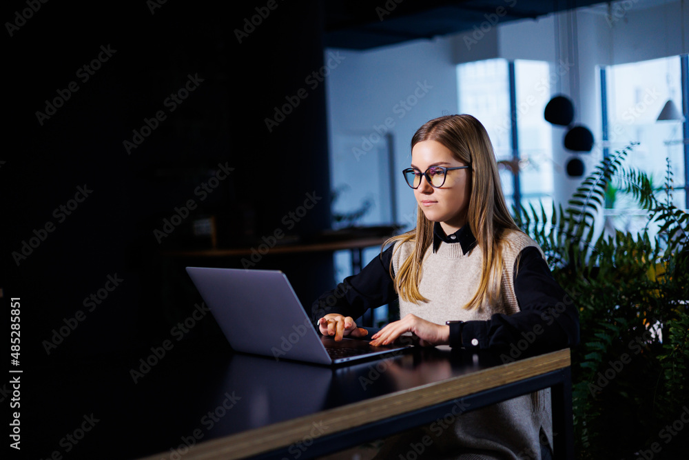 Beautiful smart attractive elegant woman businesswoman in a large company holds an online meeting with international business partners, she sits at a table at the workplace with a laptop Beautiful smart attractive elegant woman businesswoman in a large company holds an online meeting with international business partners, she sits at a table at the workplace with a laptop