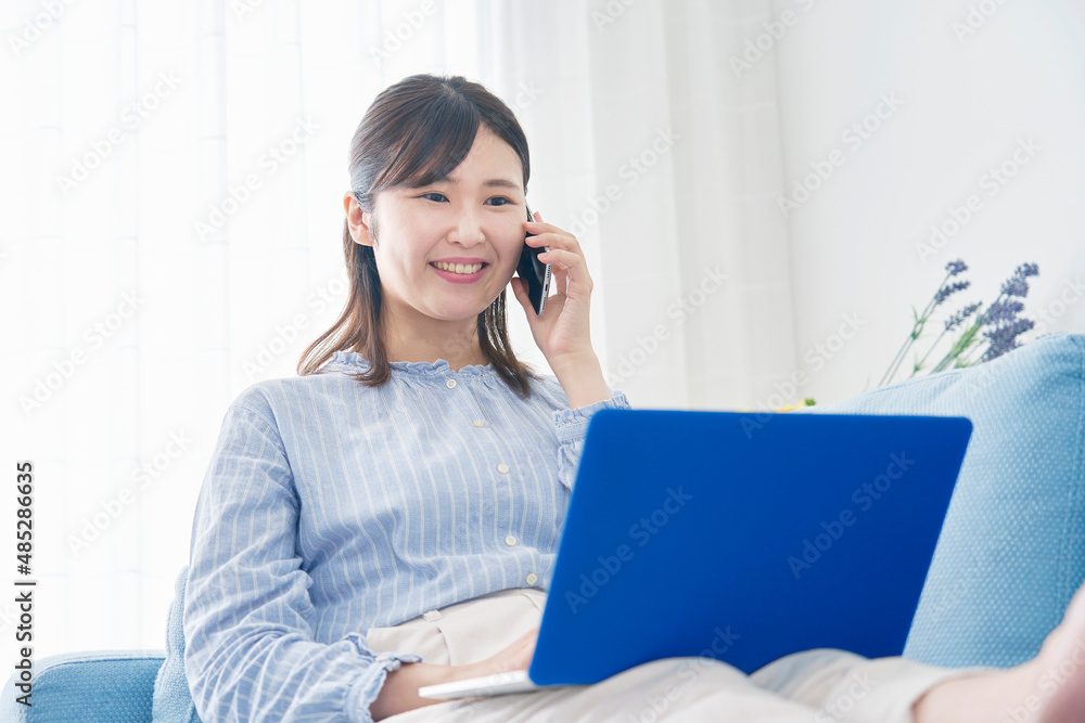 女性 電話する 笑顔 リビング 女性 電話する 笑顔 リビング