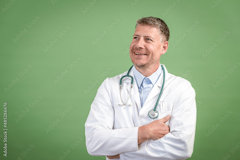 middle aged male doctor with grey hair wearing stethoscope and white coat on green background middle aged male doctor with grey hair wearing stethoscope and white coat on green background