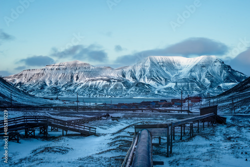 landscape with mountains and sky.
The collective heating pipes are insulated from the ground to protect the permafrost