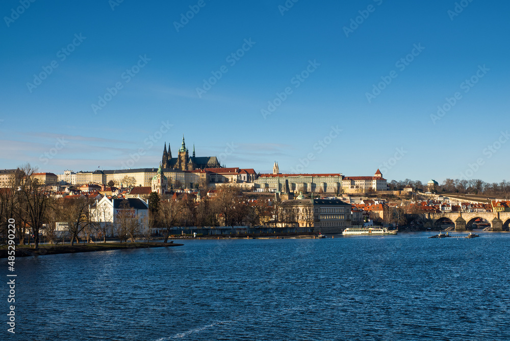 View of Prague Castle and St. Vitus Cathedral with blue sky across the Vltava River with Charles Bridge. High quality photo