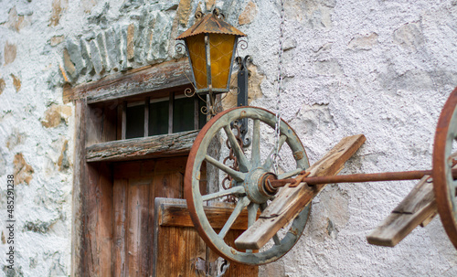 an old door with a lantern and a wagon wheel photo