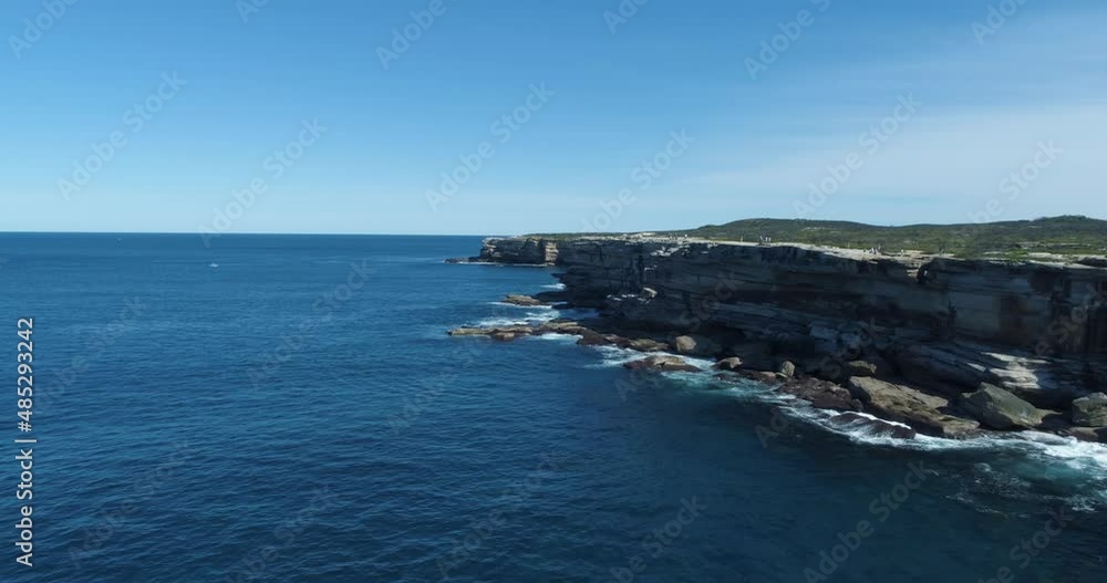 Aerial- View of amazing sandstone cliffs of Cape Solander and Sydney city on a sunny day in June- People walking along the cliff for exercise during a pandemic Aerial- View of amazing sandstone cliffs of Cape Solander and Sydney city on a sunny day in June- People walking along the cliff for exercise during a pandemic