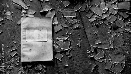 Tablou pe pânză Old notebook on the floor in the attic of old, abandoned farm house with shattered glass
