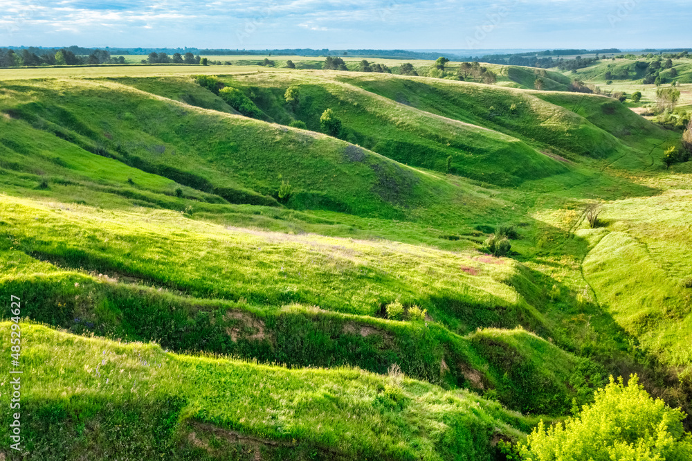 Hills slopes overgrown with green grass, nature reserve Ukrainian Iceland near Vasylkiv, Ukraine. Aerial view Hills slopes overgrown with green grass, nature reserve Ukrainian Iceland near Vasylkiv, Ukraine. Aerial view
