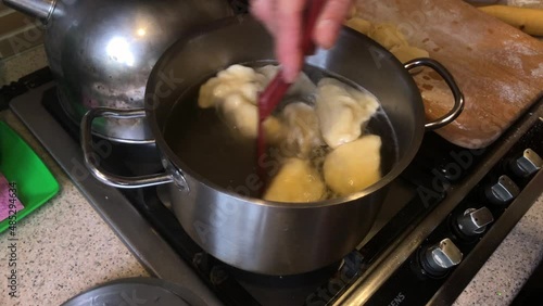 Top view on kitchen place where Ukrainian vareniky (dumplings) stuffed with fresh cherry cooking 
