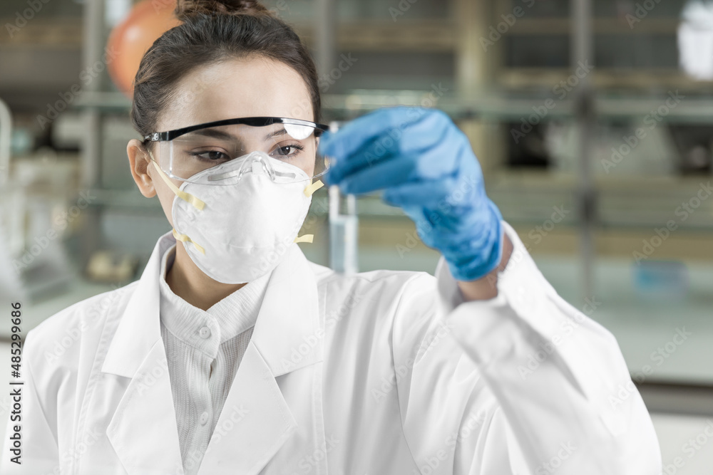 Female scientist looking at the scientific sample in the laboratory Female scientist looking at the scientific sample in the laboratory