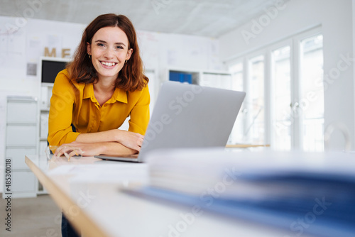 Cute friendly young businesswoman with a beaming smile