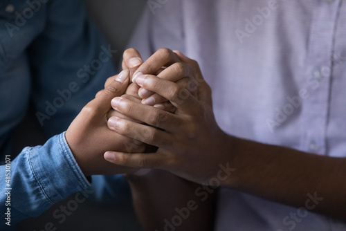 African young couple holding hands close up. Cropped shot of arms. Millennial teens enjoying closeness, expressing trust, love, care, tenderness, giving comfort, support