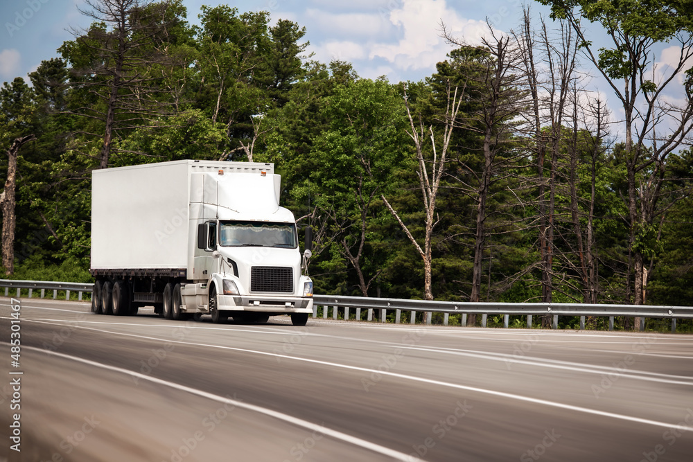 White truck with white conteiner on a road White truck with white conteiner on a road