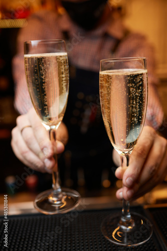 close-up of a glass of champagne poured from a bottle. photo