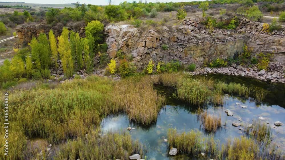 Reeds in mystery lake in flooded stone quarry with reflection of dark sky. Beautiful vast landscape Reeds in mystery lake in flooded stone quarry with reflection of dark sky. Beautiful vast landscape