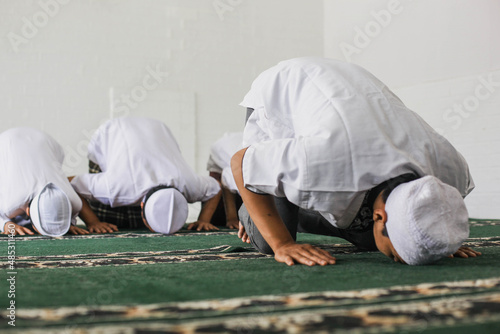 Tableau sur toile A group of Muslims are praying  in congregation with prostrating movements in th