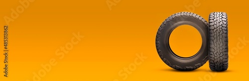new all-season at tires on an orange background. a long empty copyspace layout
