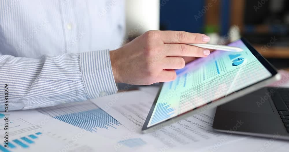 Businesswoman studying business analytics in charts on tablet closeup Businesswoman studying business analytics in charts on tablet closeup