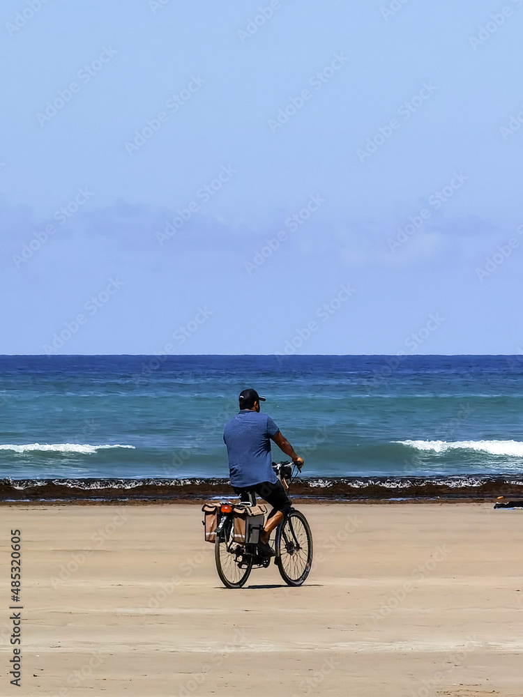 Fototapeta premium Man riding his bike on the beach