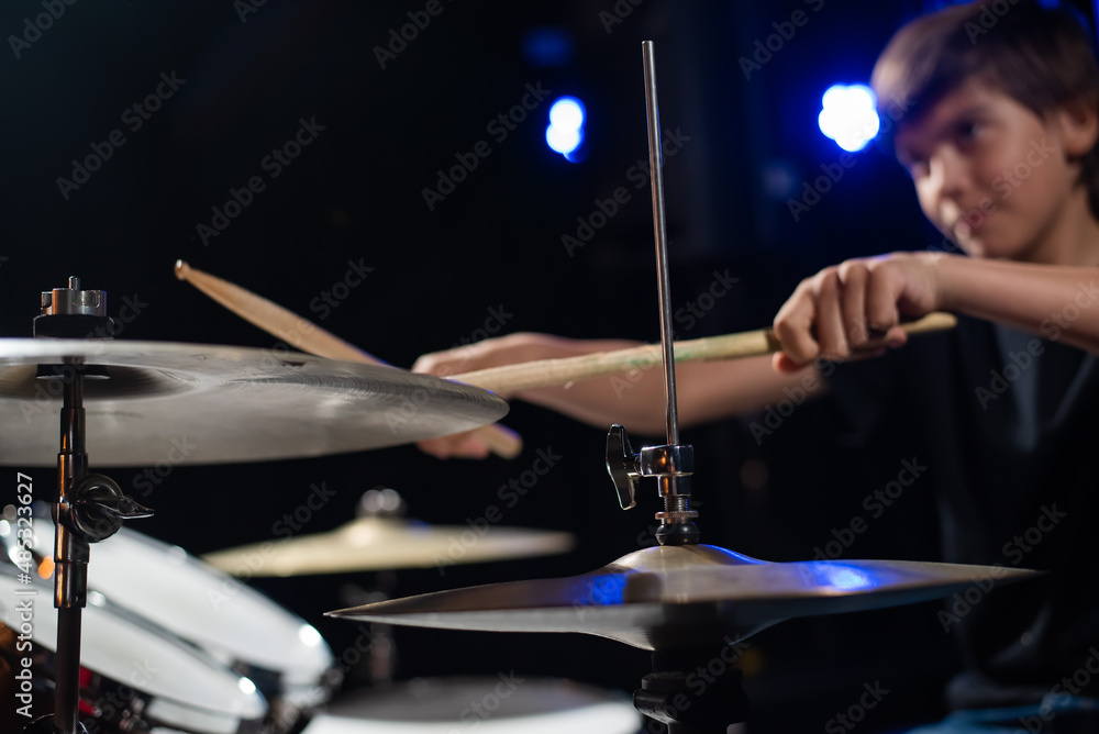 Naklejka premium A boy plays drums in a recording studio