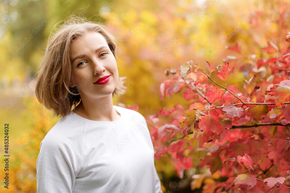 Beautiful young woman in autumn park. Season and people concept. Blonde fashion model having fun in fall park outdoors. Beautiful young woman in autumn park. Season and people concept. Blonde fashion model having fun in fall park outdoors.
