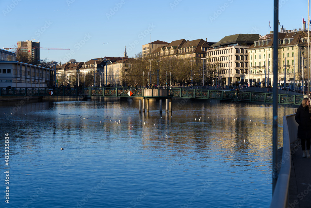 River Limmat with pedestrian bridge at downtown Zürich on a sunny winter day. Photo taken February 5th, 2022, Zurich, Switzerland.
