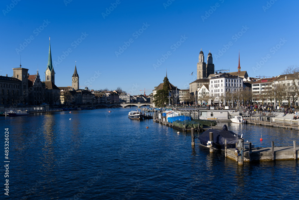Skyline of the old town of Zürich on a sunny winter afternoon with river Limmat in the foreground. Photo taken February 5th, 2022, Zurich, Switzerland.