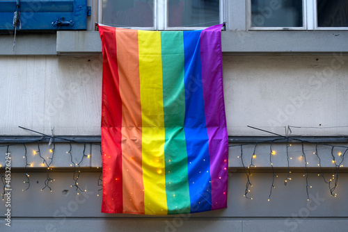 Lbgt rainbow flag hanging from window ledge at the old town of Zürich on a sunny winter day with Christmas lights. Photo taken February 5th, 2022, Zurich, Switzerland. photo