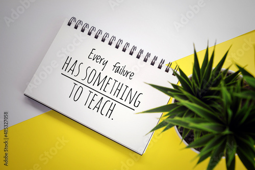 Inspirational motivational quote - Every failure has something to teach. Positive message on a spiral notebook with green plant on white and yellow table vintage background. Learn from mistakes. photo