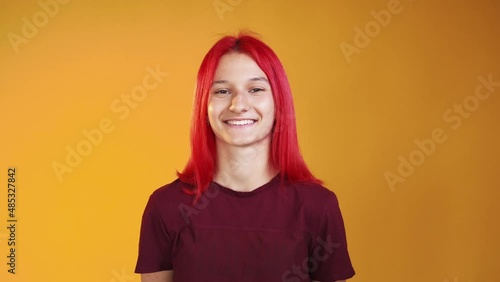Laughing woman. Positive emotion. Optimistic lifestyle. Joyful happy giggling young girl smiling wide isolated on orange free space background.