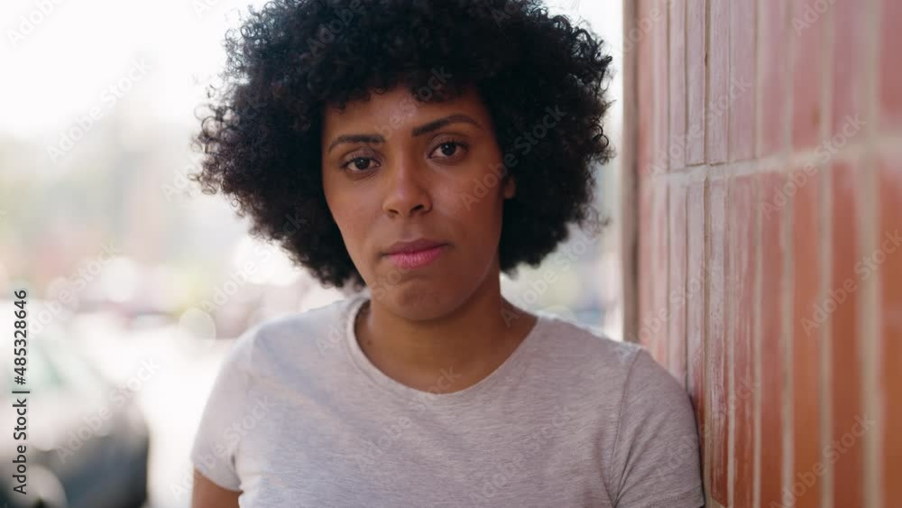 Young african american woman with serious expression standing at street Young african american woman with serious expression standing at street
