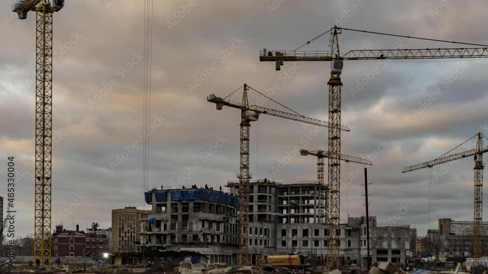Cranes working day and night on construction of the housing estate in former industrial zone, time lapse Cranes working day and night on construction of the housing estate in former industrial zone, time lapse