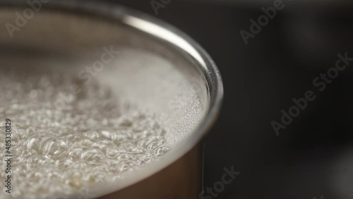 Slow motion pasta boiling in pot closeup photo