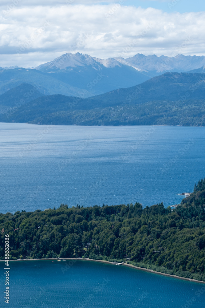 Obraz premium View of the Lake in the mountains in spring. Patagonian Coast Lake. Waves on the coast. Peninsula. Vertical Panoramic View. Vertical photo. 