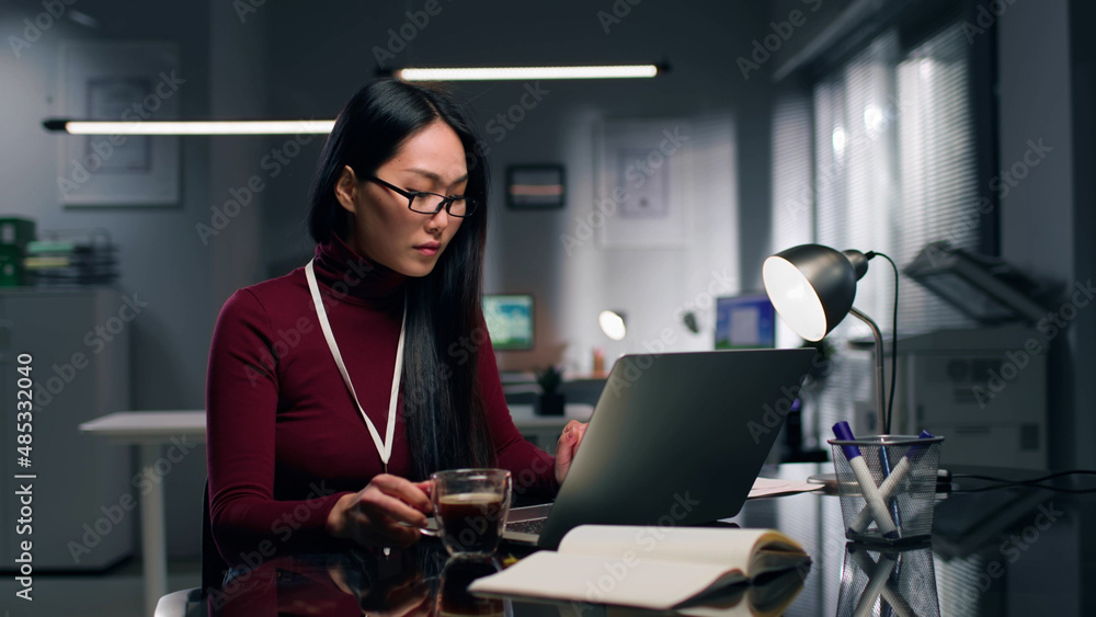 Young asian woman working on laptop in modern office. Young asian woman working on laptop in modern office.
