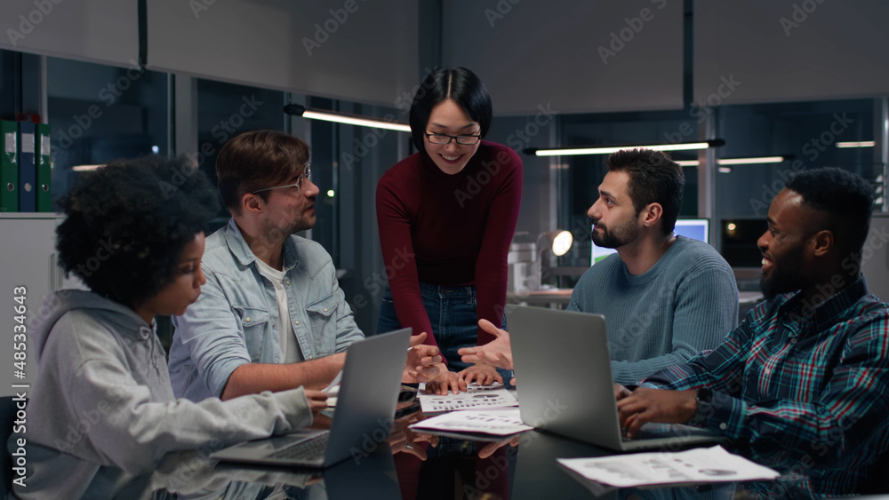 Asian businesswoman leading meeting with diverse employees in office. 