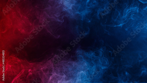 Abstract colored smoke moves on black background. Mystical swirling smoke rolling low across the ground.