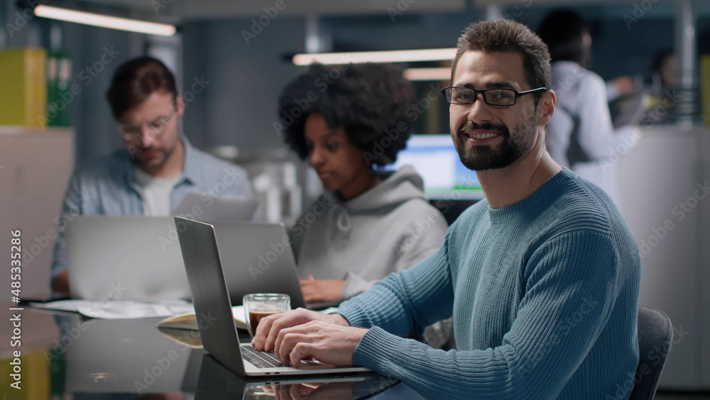 Successful entrepreneur smiling at camera working in modern startup company. Successful entrepreneur smiling at camera working in modern startup company.